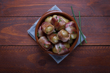 Grilled baby potato wrapped in bacon on the wooden background