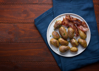 Baked baby potato with green onion on the white plate
