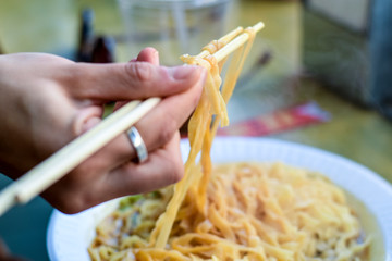 Chopsticks lifting up hot rice noodles