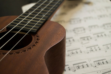 Fototapeta na wymiar ukulele in close over an old guitar music score