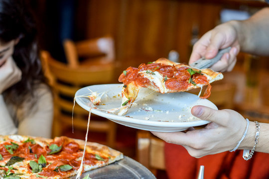 Serving cheesy thin crust pizza