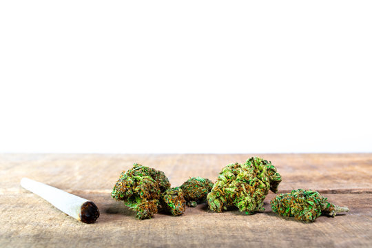 Joint mit Marijuana Cannabis Bl&uuml;ten auf Holz Unteergrund mit wei&szlig;em Hintergrund