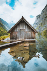 Idyllic view of traditional old wooden boat house at scenic Lake Obersee on a beautiful sunny day...