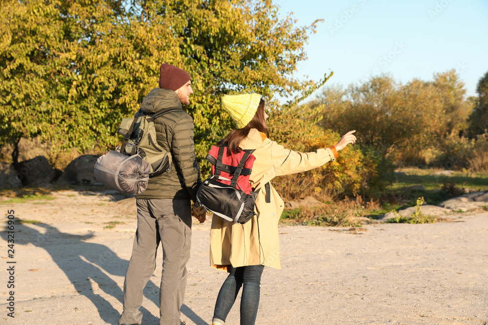 Wall mural Couple of campers with backpacks and sleeping bags in wilderness