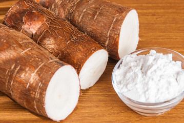Raw cassava tuber on wooden background - Manihot esculenta