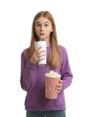 Emotional teenage girl with popcorn and beverage during cinema show on white background