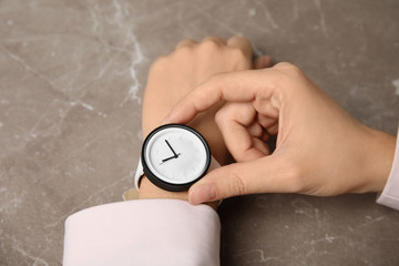 Fototapeta premium Businesswoman with stylish wrist watch at table, closeup. Time management