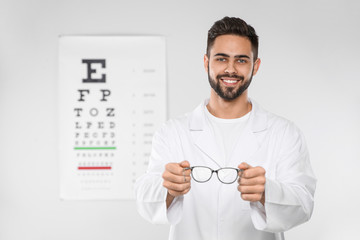 Male ophthalmologist with eyeglasses in clinic. Space for text