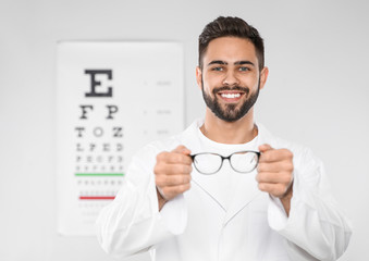 Male ophthalmologist with eyeglasses in clinic. Space for text