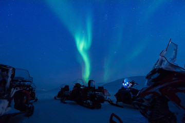The polar arctic Northern lights aurora borealis sky star in Norway Svalbard in Longyearbyen the snowmobile mountains