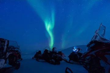 Fotobehang The polar arctic Northern lights aurora borealis sky star in Norway Svalbard in Longyearbyen the snowmobile mountains © bublik_polina