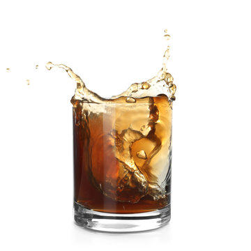 Glass of expensive whiskey with splash on white background