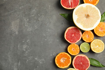 Different citrus fruits on grey background, top view. Space for text