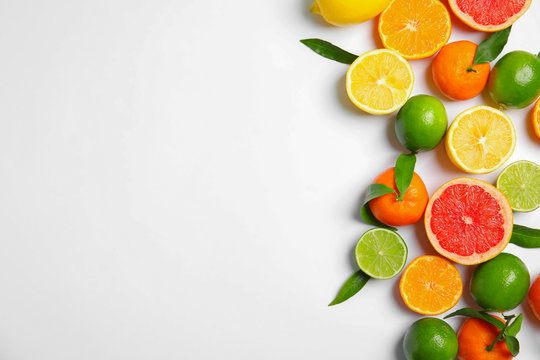 Different citrus fruits on white background, top view. Space for text