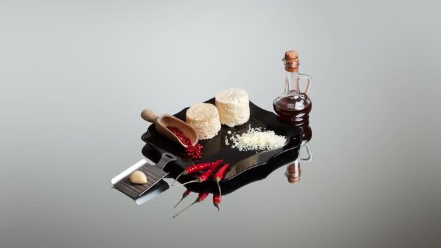 Art composition in the genre of still life with ricotta cheese, chilli peppers and a bottle of tincture