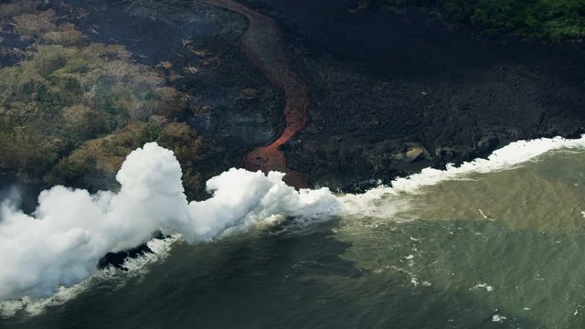 Aerial view of molten volcanic lava entering ocean