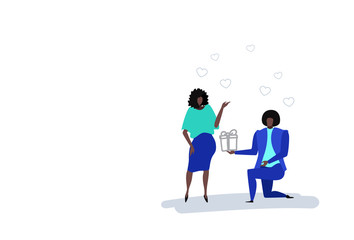 Man kneeling holding gift box engagement ring