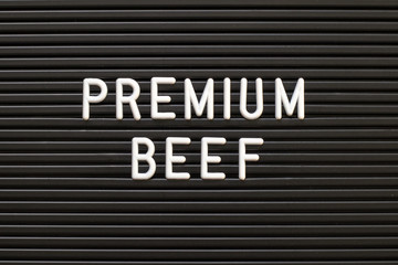 Black color felt letter board with white alphabet in word premium beef background