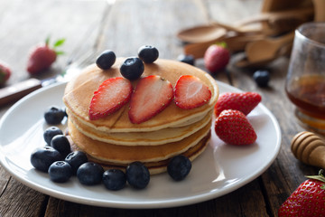 Delicious pancakes with Strawberry and blueberry on wooden table.top view