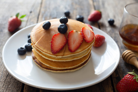 Delicious pancakes with Strawberry and blueberry on wooden table.top view