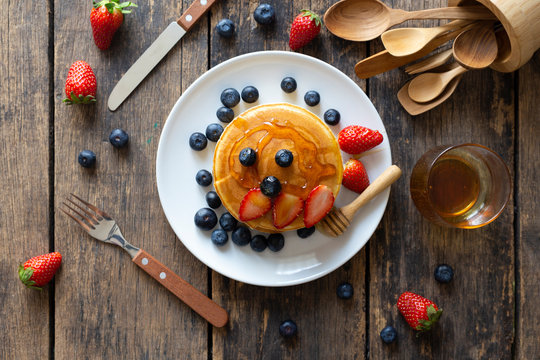 Delicious pancakes with Strawberry and blueberry on wooden table.top view