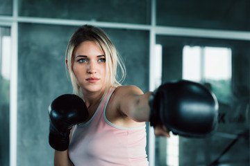 Female boxer is training punching in fitness gym.,Portrait of boxing woman is practicing footwork...