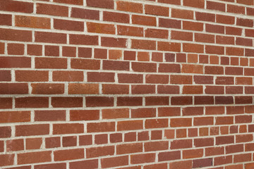 Obraz premium Grungy vintage reddish brown brick wall in common bond pattern (angle view)