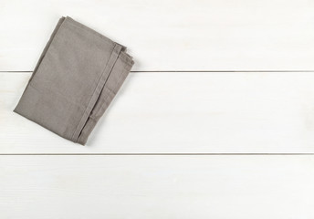 Grey dishcloth on white wooden plank table flat lay top view from above