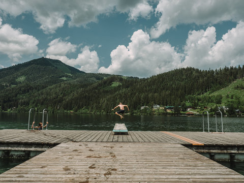 Rear view of shirtless boy diving in lake