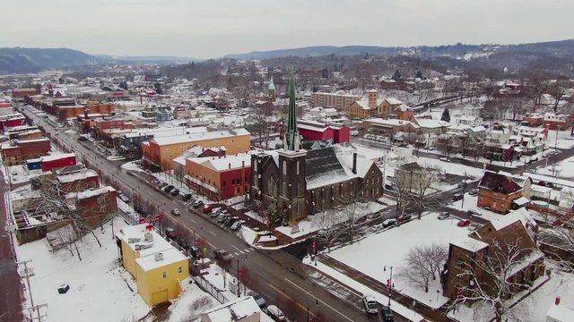 A slow aerial orbit around the business district of a typical Pennsylvanian river town at Wintertime. Pittsburgh suburbs.  	