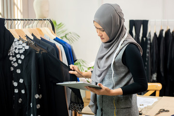 Muslim woman designer as a startup business owner working in tailor shop