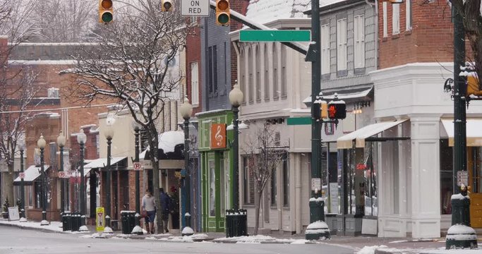 A long shot of a small American town's business district in the winter season. Pittsburgh suburbs. Snowing version.  	