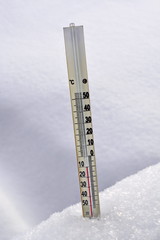 Mercury thermometer in the snow showing negative temperature Celsius