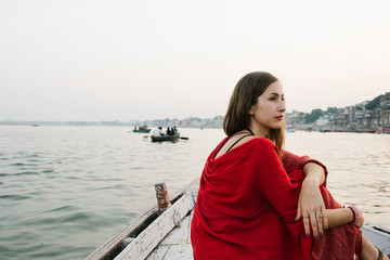 Fototapeta premium Western woman on a boat exploring the River Ganges