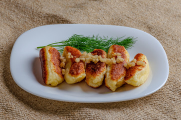 Fried cheese and kefir sticks served in white plate. Made from cheese, flour and kefir.