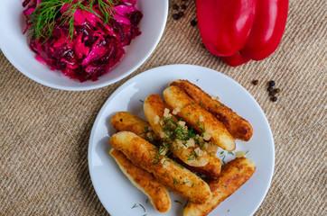 Breaded cheese and kefir sticks. Made from cheese, flour and kefir. Served with red salad.