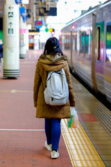 young girl walking at high speed train station waiting for train 