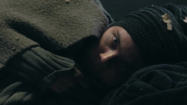 War victim warming up under blanket, hiding in bomb shelter, hope of salvation