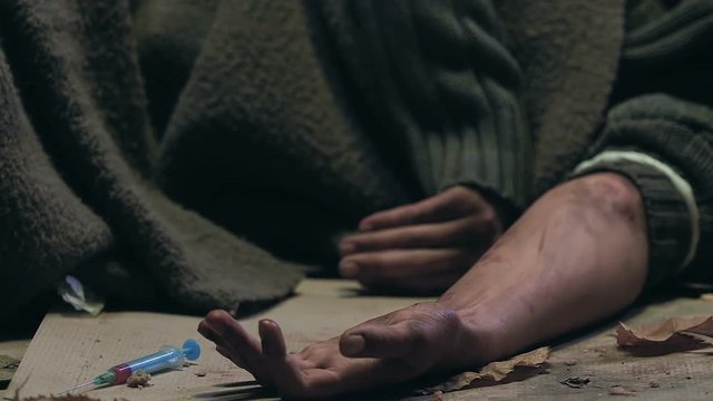 Drug addict having seizure lying on street, dying of heroin overdose, closeup
