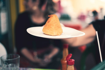 Person holding a plate with a coxinha
