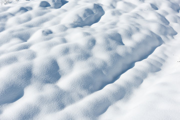 Fototapeta na wymiar Large snowdrifts on a snowy field