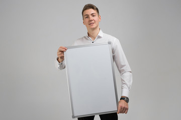 Portrait of young man with clean magnetic Board in his hands isolated on white background