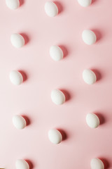 White eggs on a light pink background with reflection of the shadows and copy space. layout to easter. Flat lay, pattern