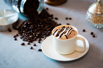 cup of coffee with whipped cream and beans