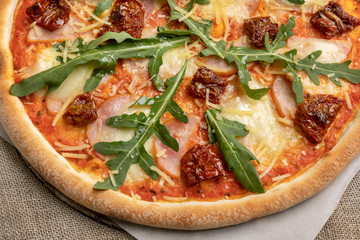 delicious pizza on a cloth tablecloth. the arugula on the pizza. cloth tablecloth on the table. restaurant menu
