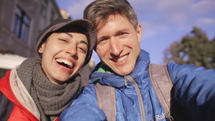 romantic enamoured couple hugging and making selfie during the city walk. Two lovers Enjoying spending time together at the warm autumn or spring day.