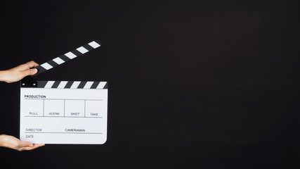 Two Hand's holding white Clapperboard or Clap board or movie slate use in video production ,film, cinema industry on black background.