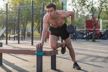 Fototapeta premium Muscular man lifts the dumbbell. Back exercise. Single arm dumbbell row.