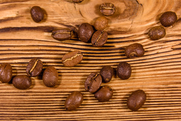 Scattered coffee beans on a wooden table. Top view