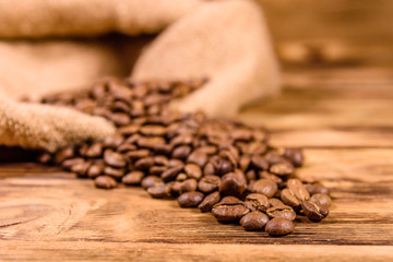 Sackcloth and scattered coffee beans on wooden table